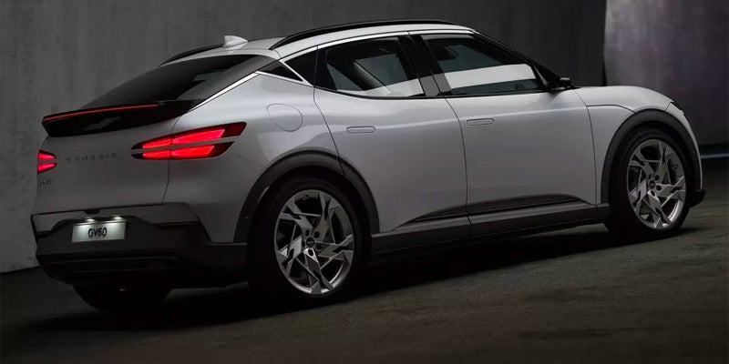 An all-new 2024 Alta White Genesis GV60 parked on a ramp between levels in a parking garage. - Genesis of Baton Rouge, LA