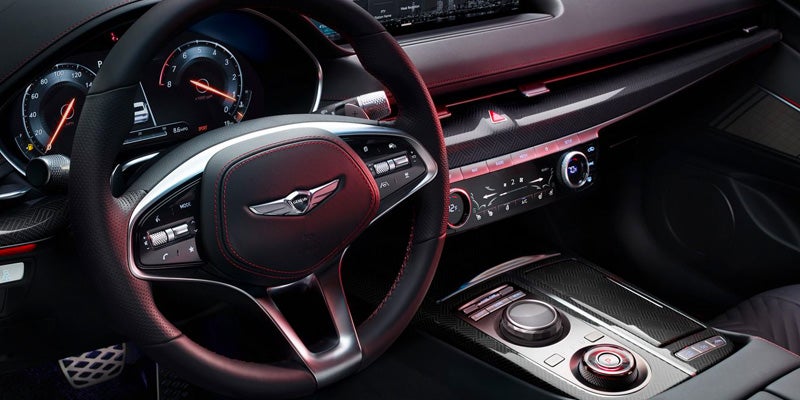 The interior of an all-new2024 Genesis G80. Black leather with red stitching and lights. - Genesis of Baton Rouge, LA