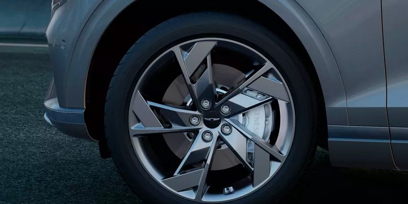 The front driver side wheel and rim of an all new silver Genesis Electrified GV70. - Genesis of Baton Rouge, LA